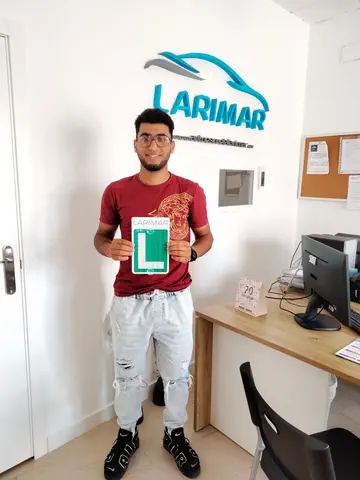 Foto de un aprobado: placa L en mano en la oficina de Autoescuela Larimar