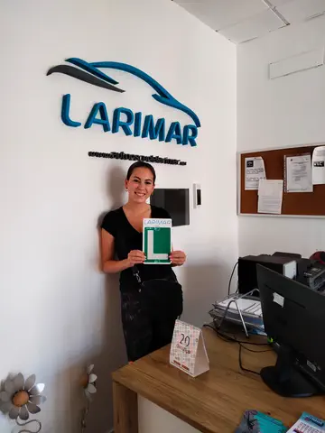 Foto de un aprobado: placa L en mano en la oficina de Autoescuela Larimar